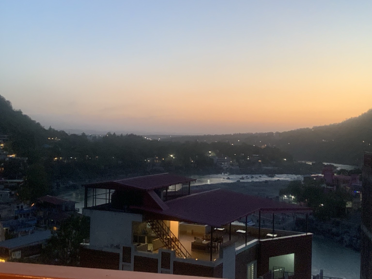 Evening above a river: a warm horizon, buildings and the first lights